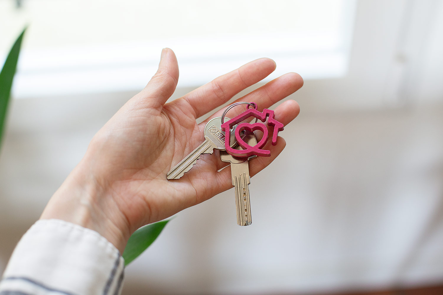 Une main soutient une clé avec le logo de Toit à Moi en porte-clé