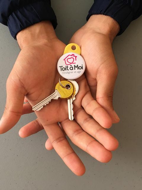 Des mains tiennent des clés avec un badge "Toit à Moi"