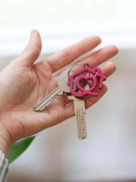 Une main soutient une clé avec le logo de Toit à Moi en porte-clé