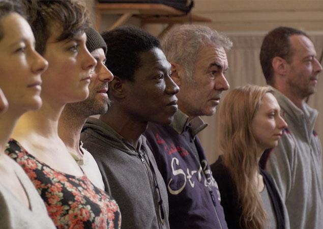 Photo extraite du film "Le temps qu'il faudra" de Florence Mary présentant plusieurs personnes alignées durant un atelier artistique