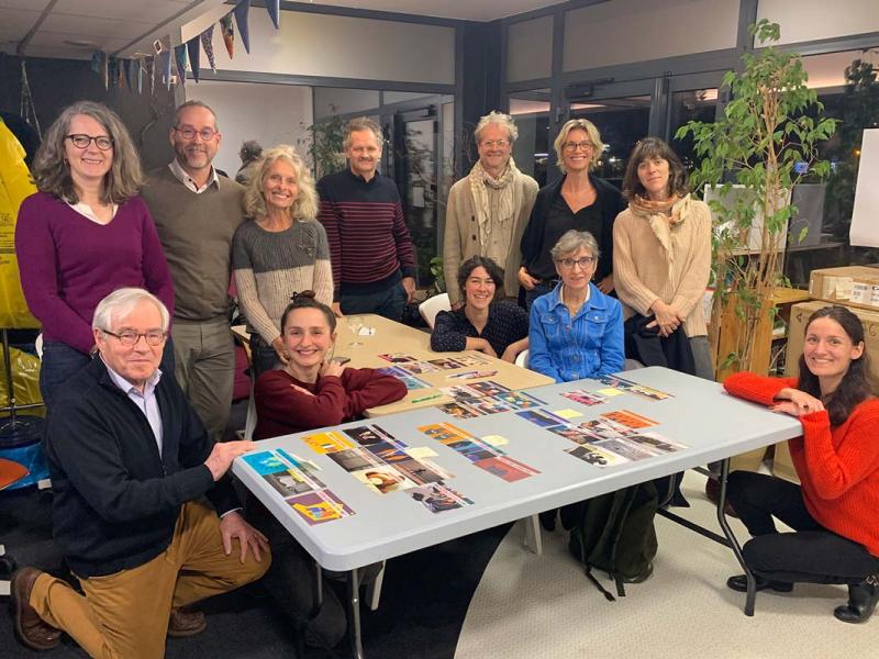 Des participants à l'atelier Fresque posent devant les cartes de jeu