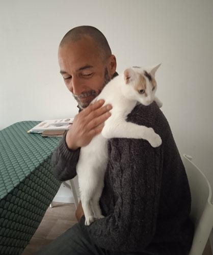 Abdella et sa chatte dans leur logement-tremplin à Limoges Abdella porte un chat sur son épaule d'un geste protecteur