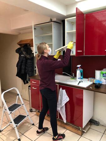 Une bénévole installe et lave les placards de la future cuisine d'un logement Toit à Moi Une bénévole installe et lave les placards de la future cuisine d'un logement Toit à Moi