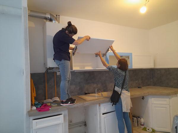 des bénévoles font des travaux dans la cuisine d'un appartement à Marseille